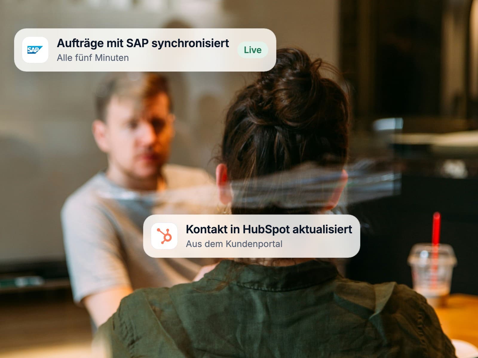 Two colleagues talking through a project behind a glass wall