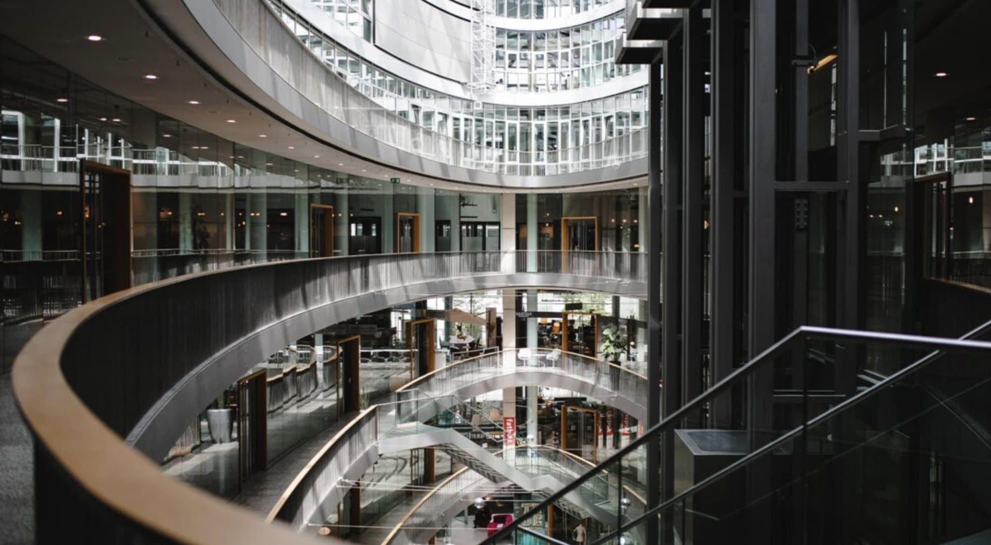 The atrium of the Düsseldorf building, with curved glass galleries over several floors